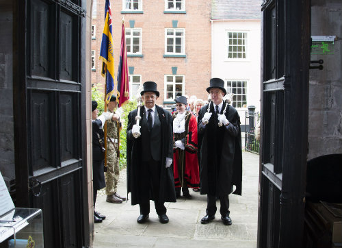 two mace bearers stand in the doorway to St Lawrences in ceremonial dress