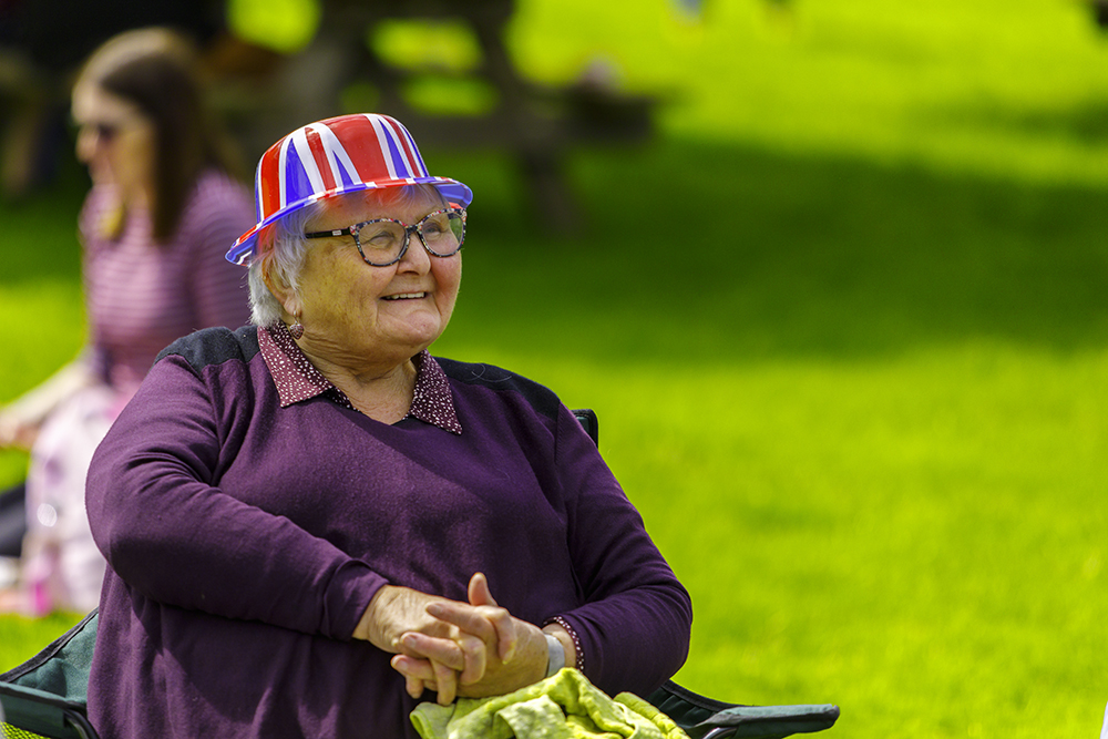 Lady smiling sat with a coronation hat on