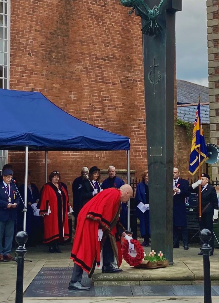 the mayor lays a wreath with councillors and veterans in parade dress behind