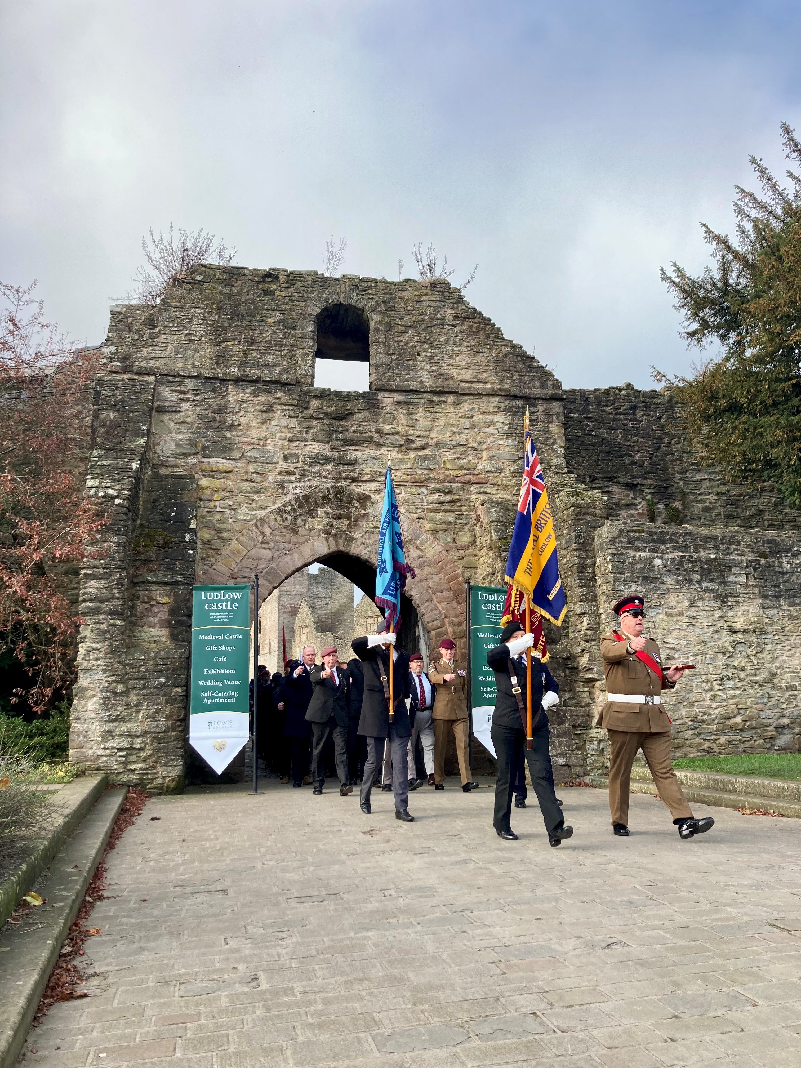 the parade marshall and standard bearers lead the parade through the castle gate
