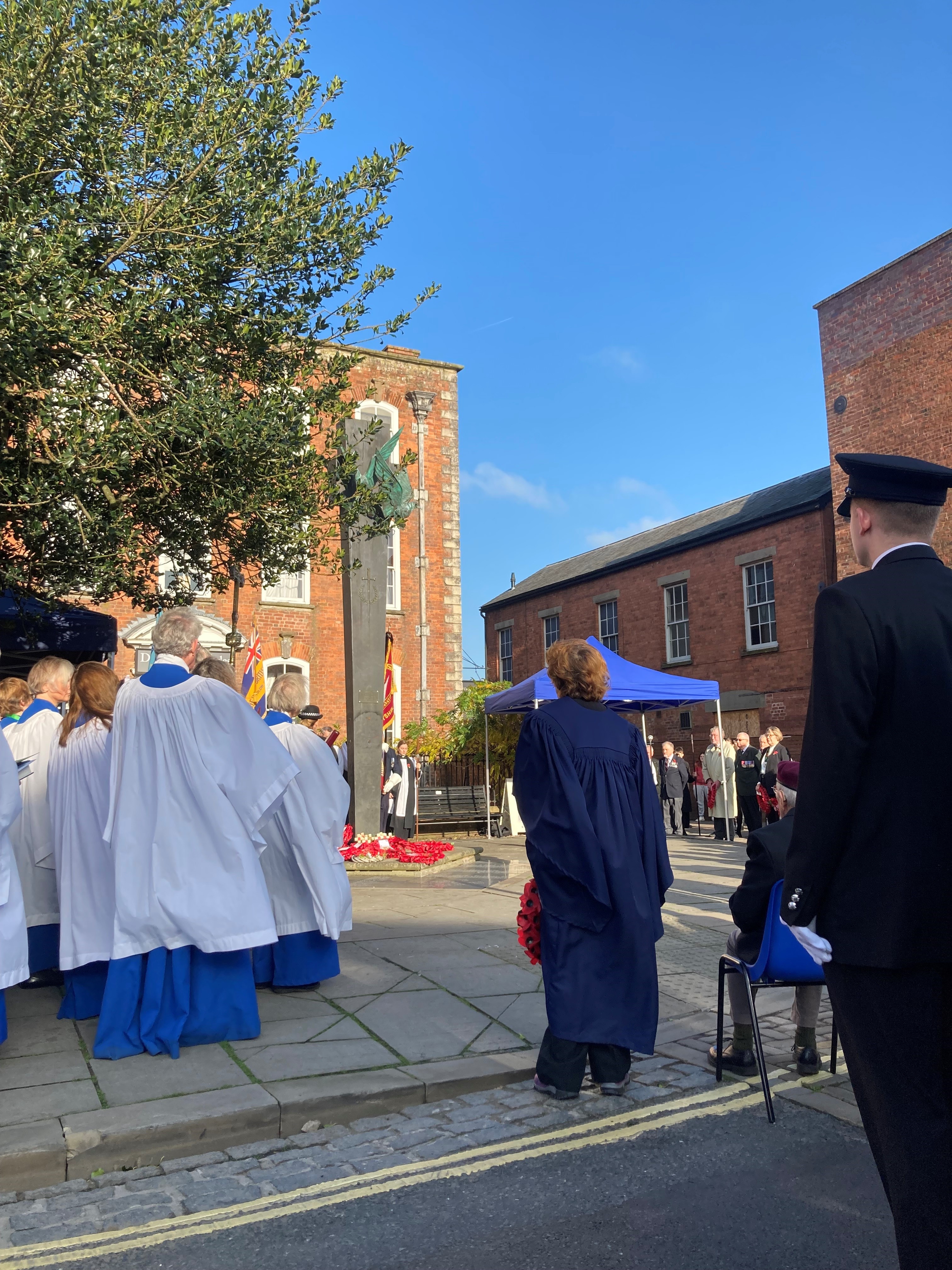 the congregation faces the memorial with wreaths in their hands waiting to display them