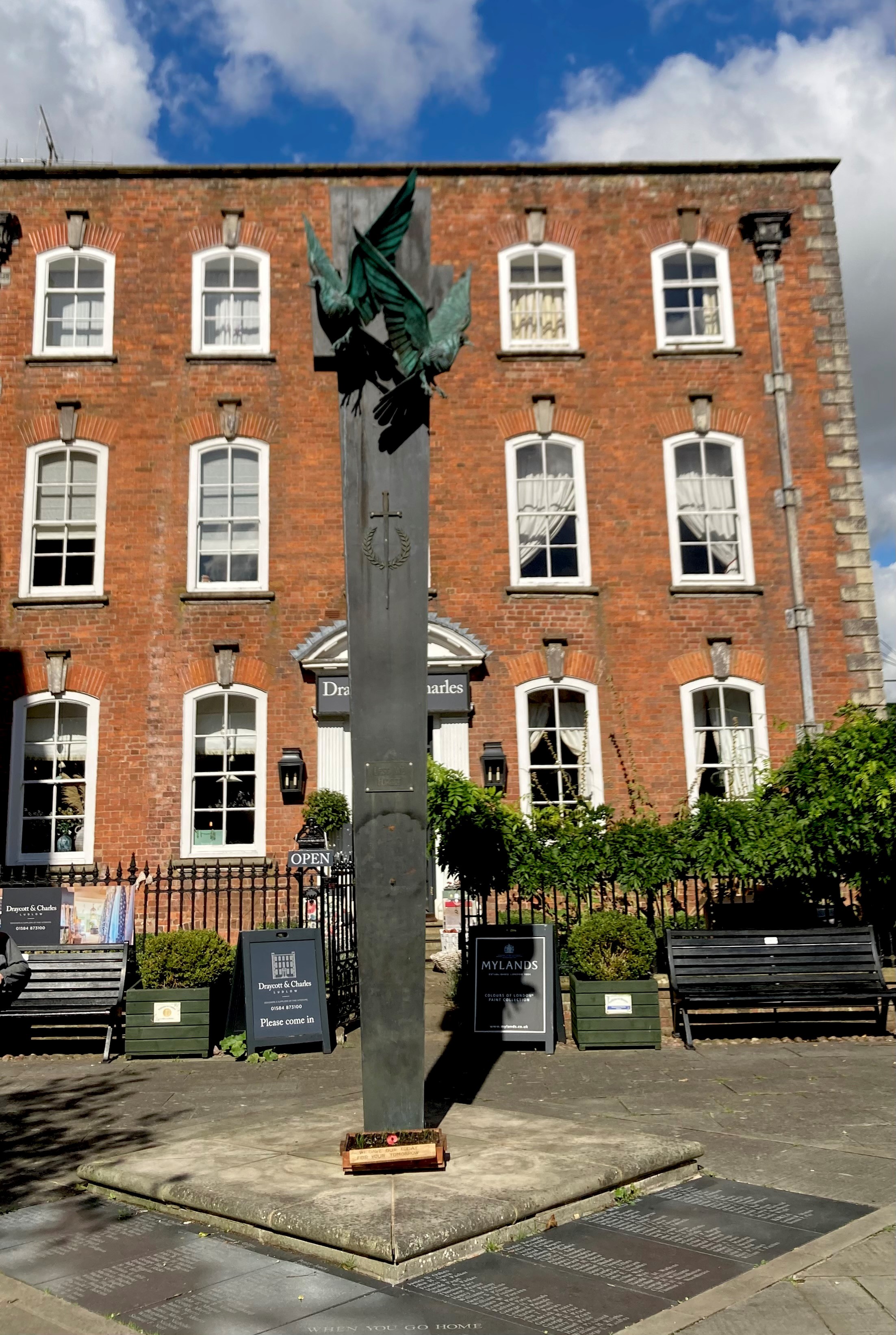 a bronze pillar topped with flying doves